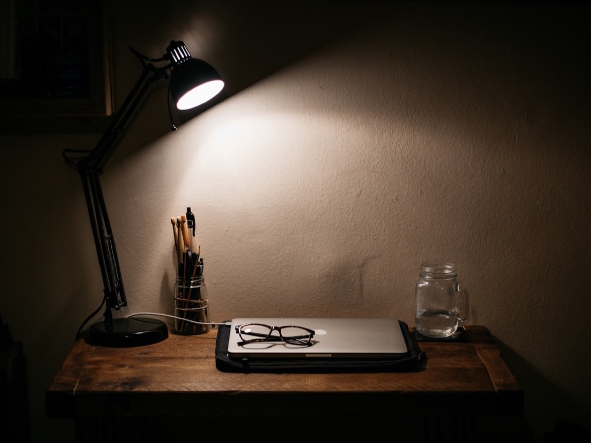 A single armchair in warm lamp light, book on the arm.