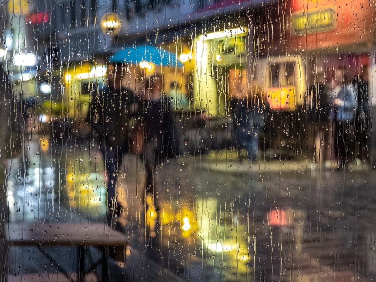 A woman in a taxi at night, city lights in the window.